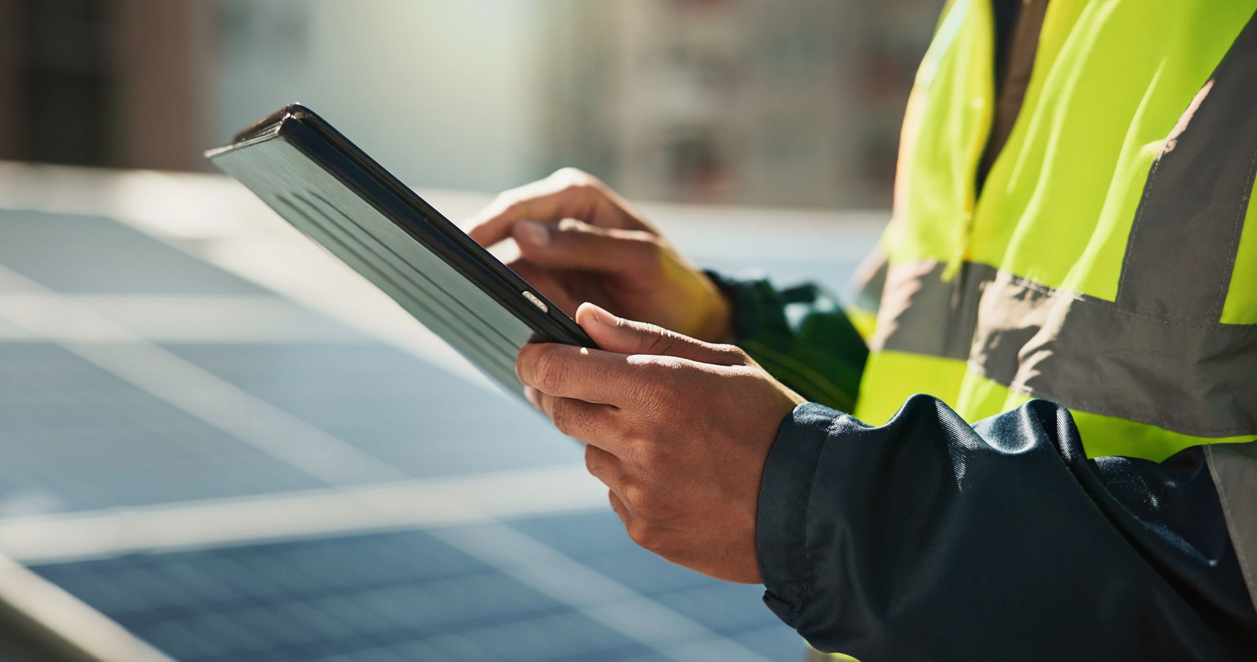 Engineer inspecting solar panels with a tablet