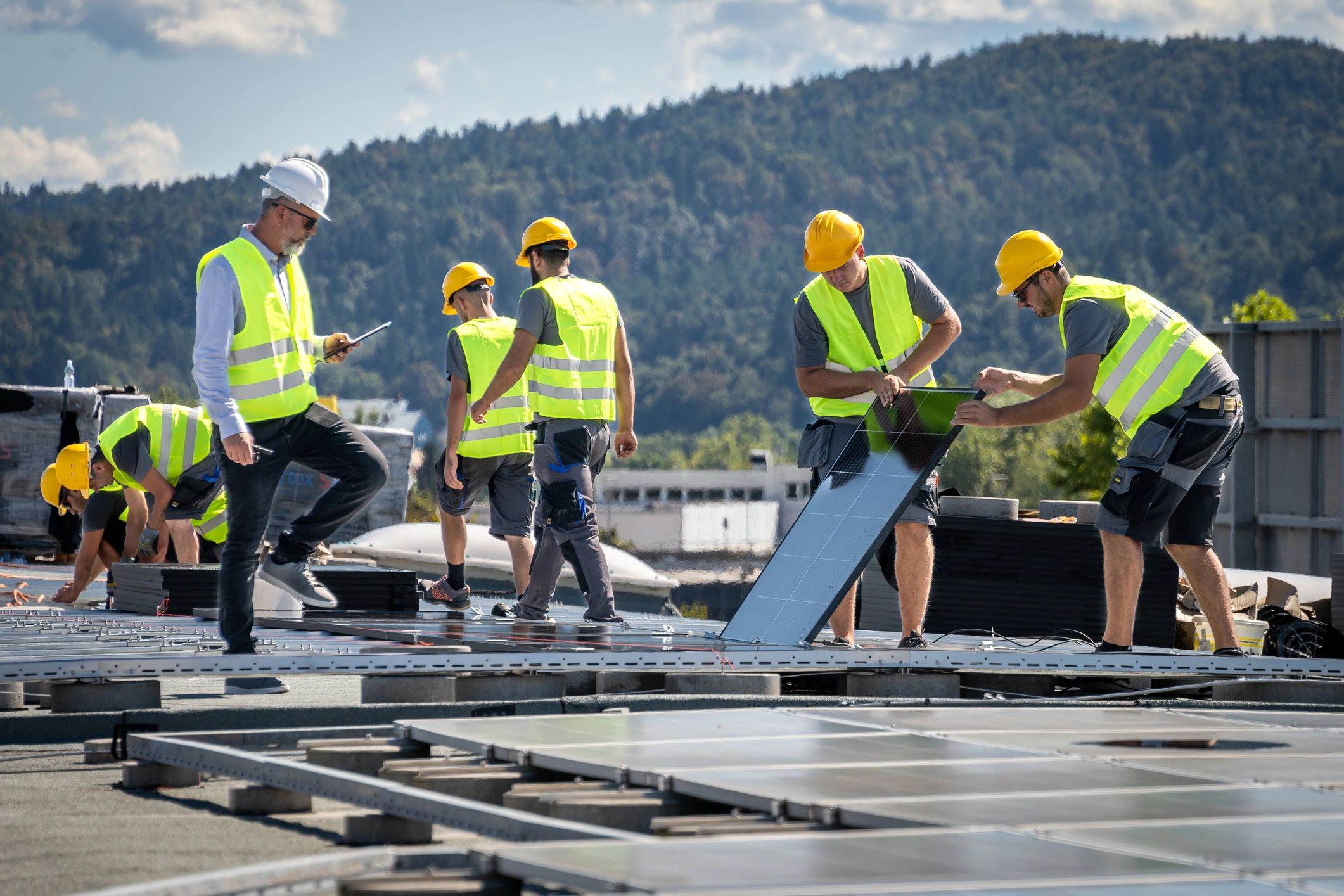 Team coordinating solar panel installation on a rooftop